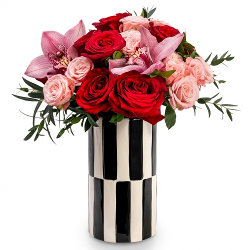 Orchids and roses in a black and white vase